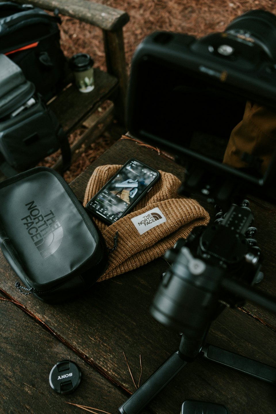 Outdoor gear and camera equipment on a wooden table.